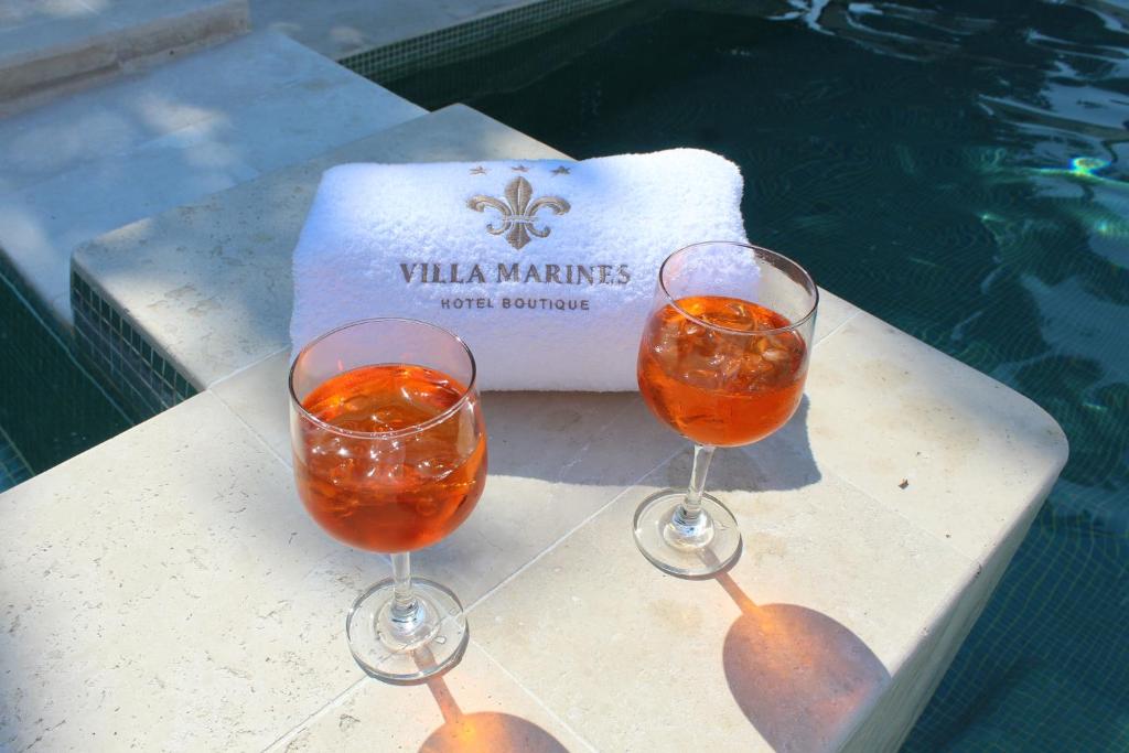 two wine glasses sitting on a table next to a pool at Villa Marines Cuernavaca in Cuernavaca