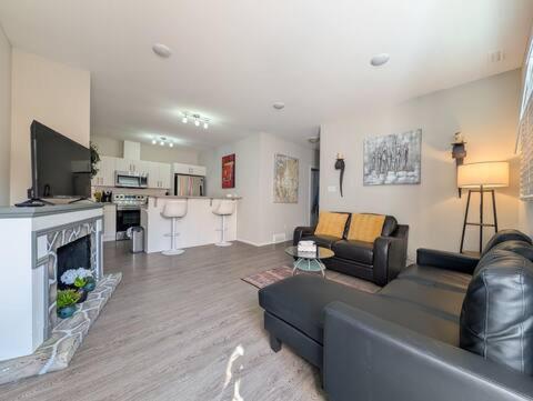 a living room with a couch and a fireplace at Villa Meadows Lethbridge in Lethbridge
