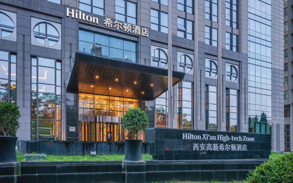 a building with a tree in front of it at Hilton Xi'an High-tech Zone in Xi'an
