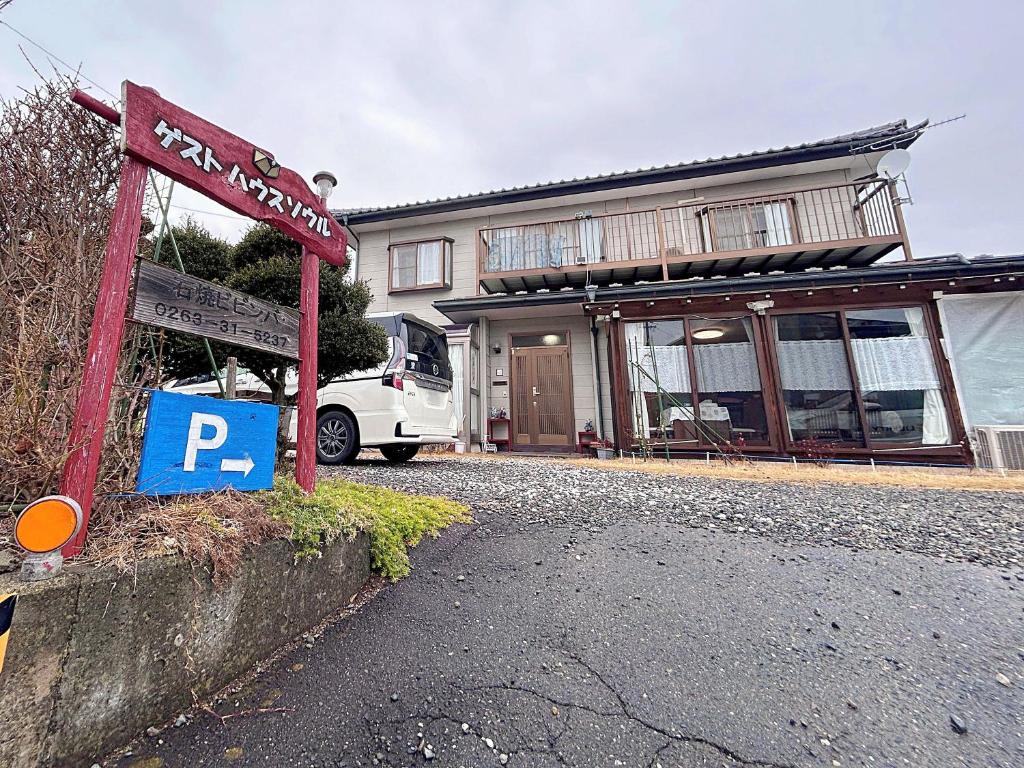 a house with a parking sign in front of it at ゲストハウス ソウル in Azumino
