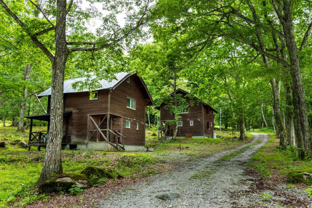 a barn and a house in the woods at Yamanomura Campsite in Hida