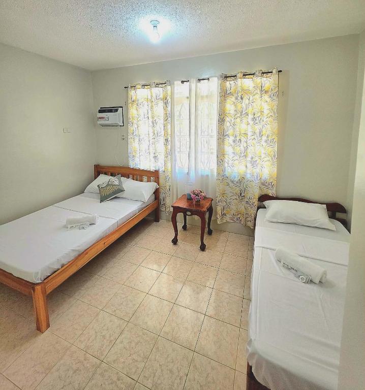 a room with two beds and a table in it at Teena Verde in Puerto Princesa City