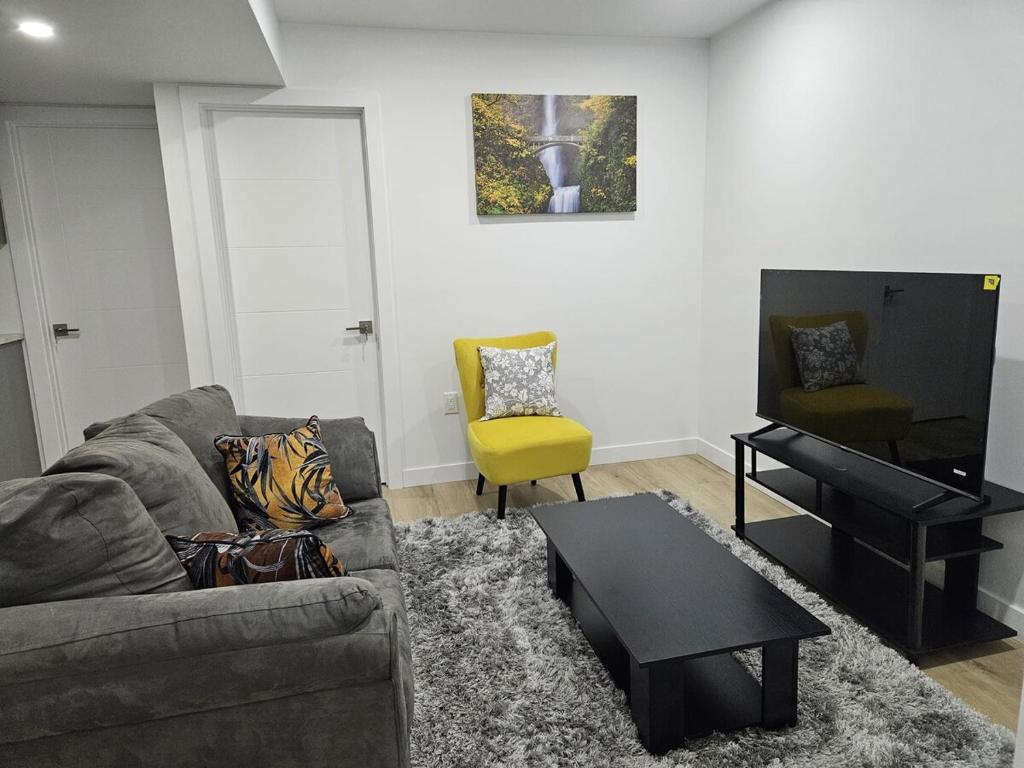 a living room with a couch and a table at Transcona Stay in Winnipeg