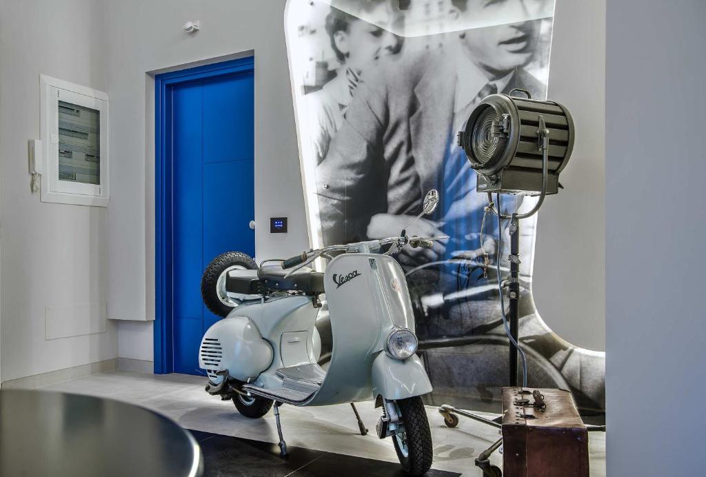 a scooter parked in a room with a blue door at Via Veneto Prestige Rooms in Rome