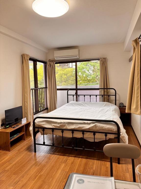 a bedroom with a bed and a television in it at Harenohi hakushima in Hiroshima
