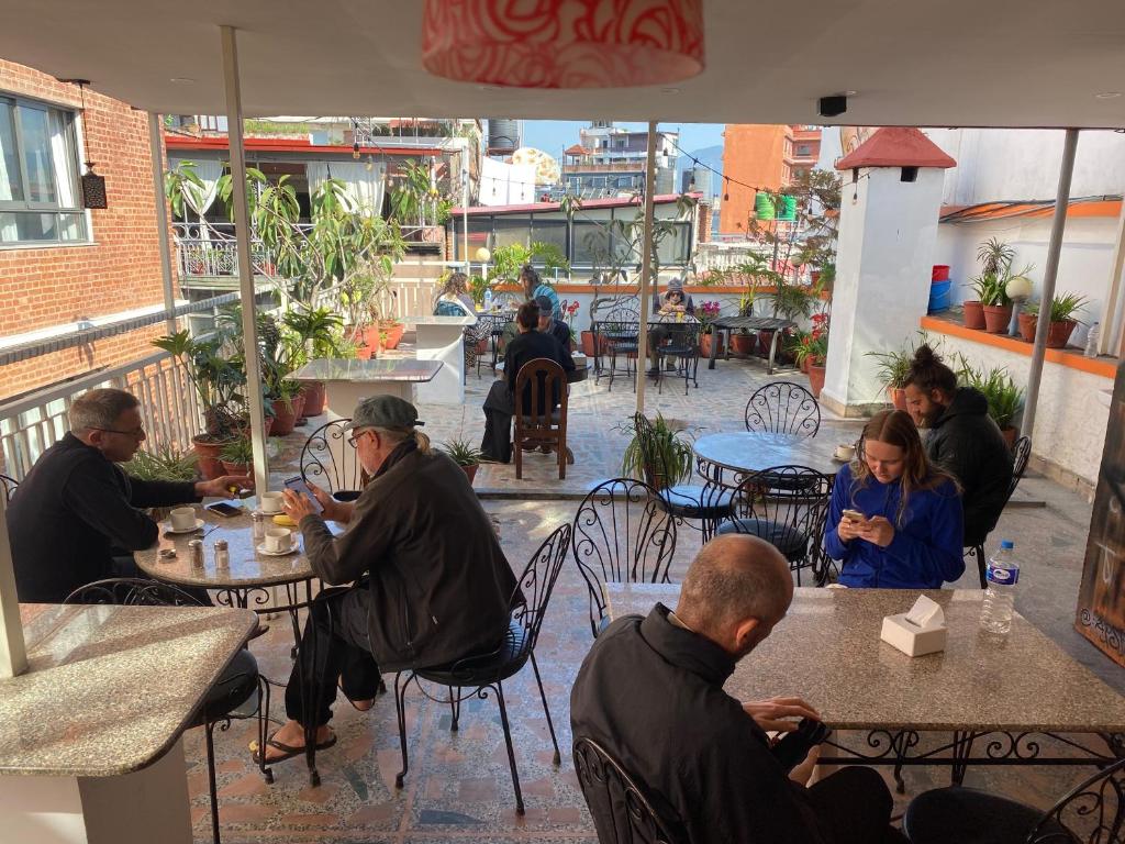 a group of people sitting at tables in a restaurant at Khangsar Home in Kathmandu