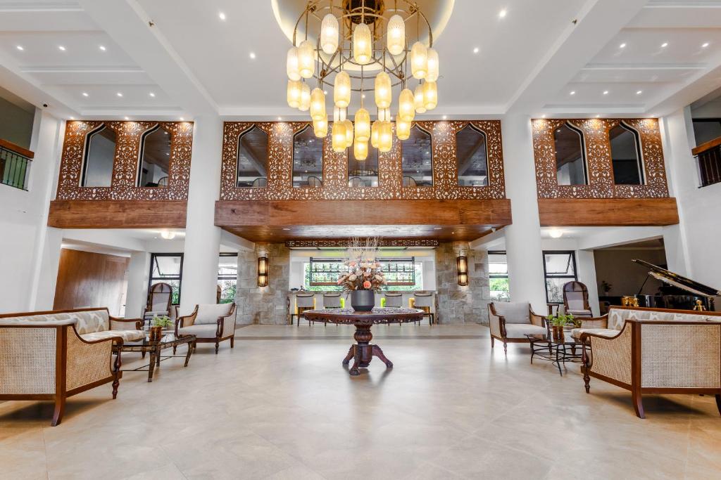 eine Lobby mit Tisch und Stühlen sowie einem Kronleuchter in der Unterkunft Java Hotel in Laoag