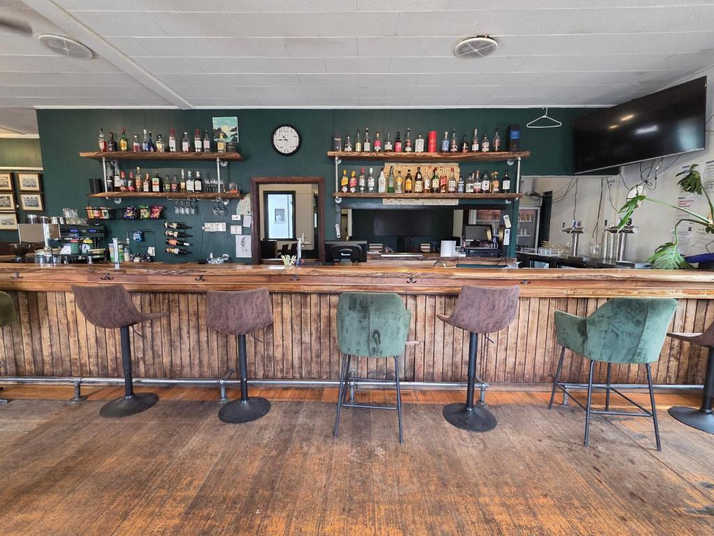 a bar with four chairs and a counter at The Caramut Hotel in Caramut