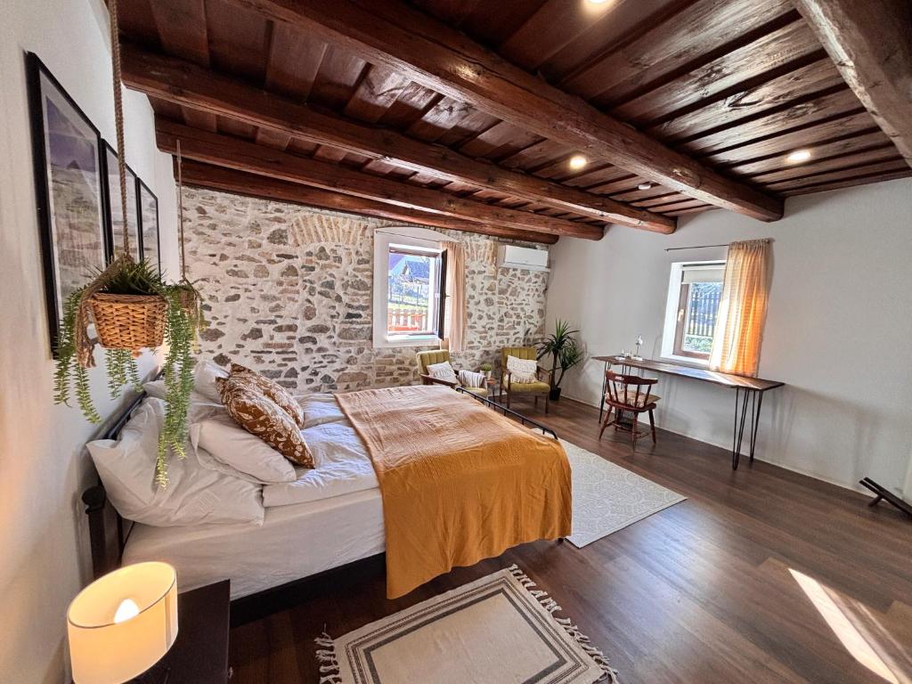 a bedroom with a bed and a stone wall at Dandelion Vintage in Nemesgulács
