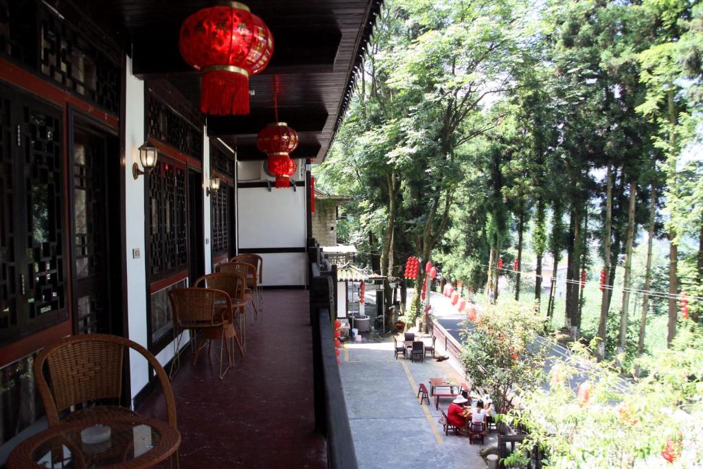uma vista para o exterior de um restaurante com mesas e cadeiras em Enshi Grand Canyon Chunlun Farmstay em Enshi