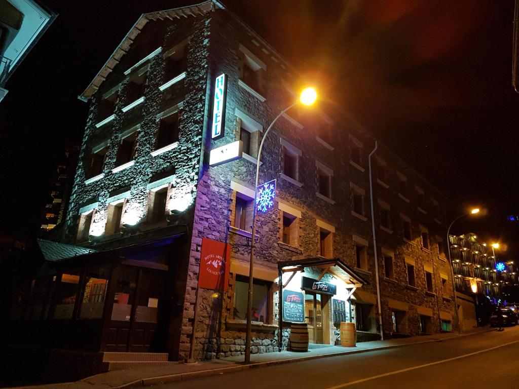 a lit up building on a street at night at Hotel Arinsal in Arinsal