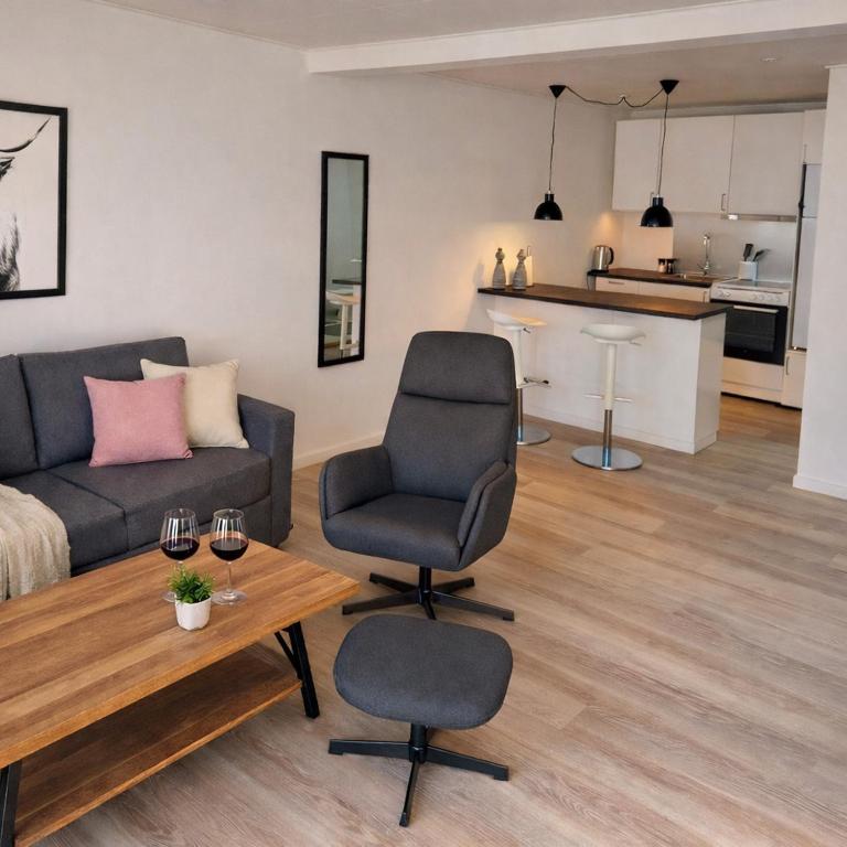 a living room with a couch and a chair and a table at Finnsvej 12E in Frederikshavn