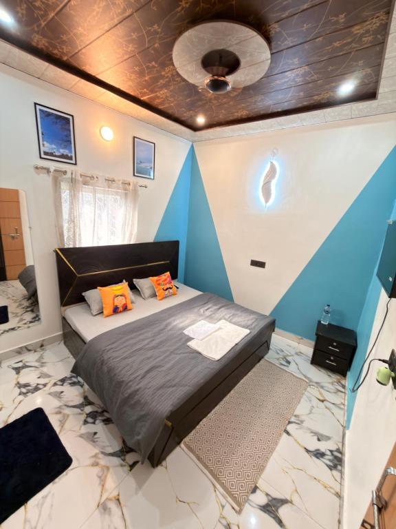 a bedroom with a bed and a blue wall at Yovibe Stays, Dorms & Rooms, Assi Ghat, Varanasi in Varanasi