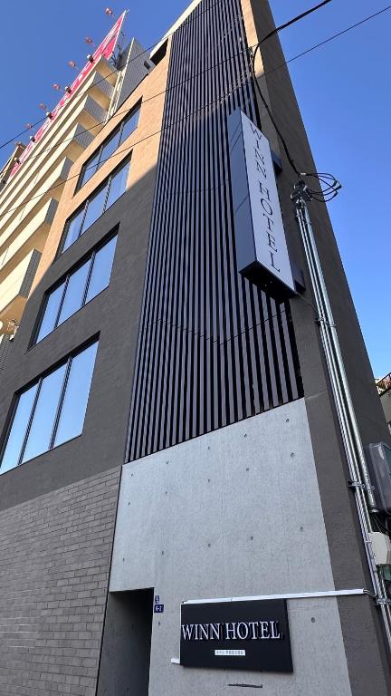 a tall building with a clock on the side of it at WINN hotel in Tokyo