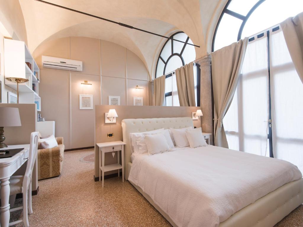een slaapkamer met een groot wit bed en een bureau bij Suite Prestige Verona in Verona