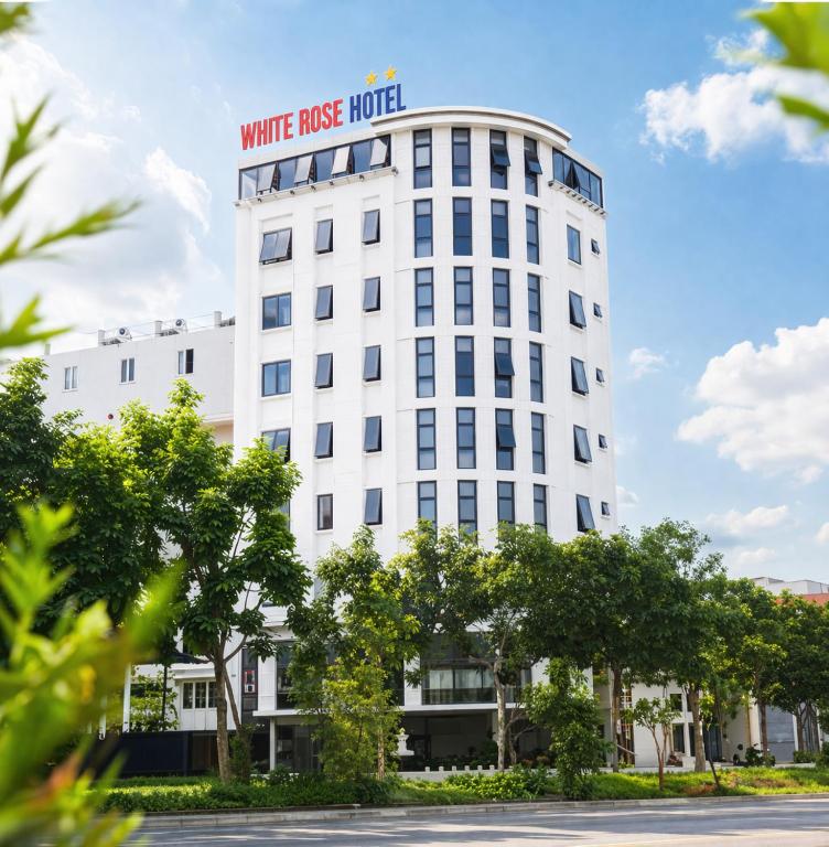 a white building with a sign on it at White Rose Hotel in Dong Hoi