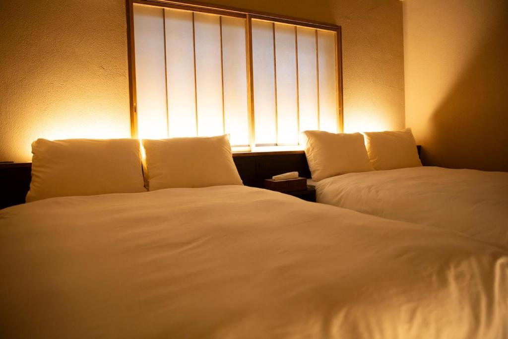 two beds in a room with a window at modern villa, asterisk ONOMICHI 2 in Onomichi