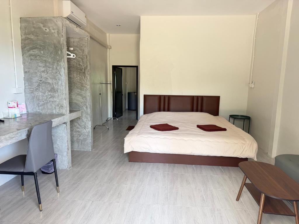 a bedroom with a large bed and a table at I mee Lanta Home in Phra Ae beach