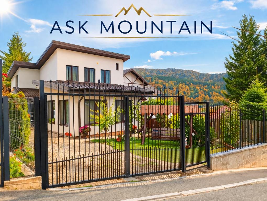 a house with a gate in front of a xk mountain at ASK MOUNTAIN in Buşteni