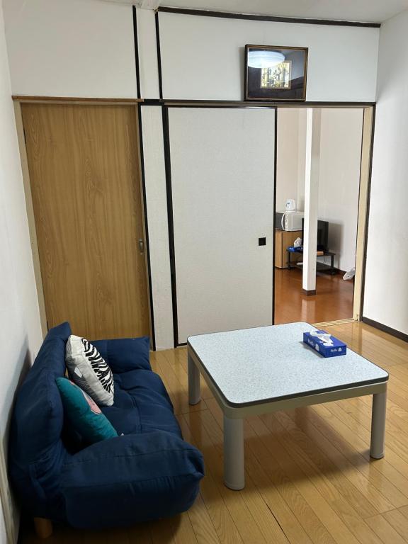 a living room with a blue couch and a table at 馨誠小屋201 in Tokyo