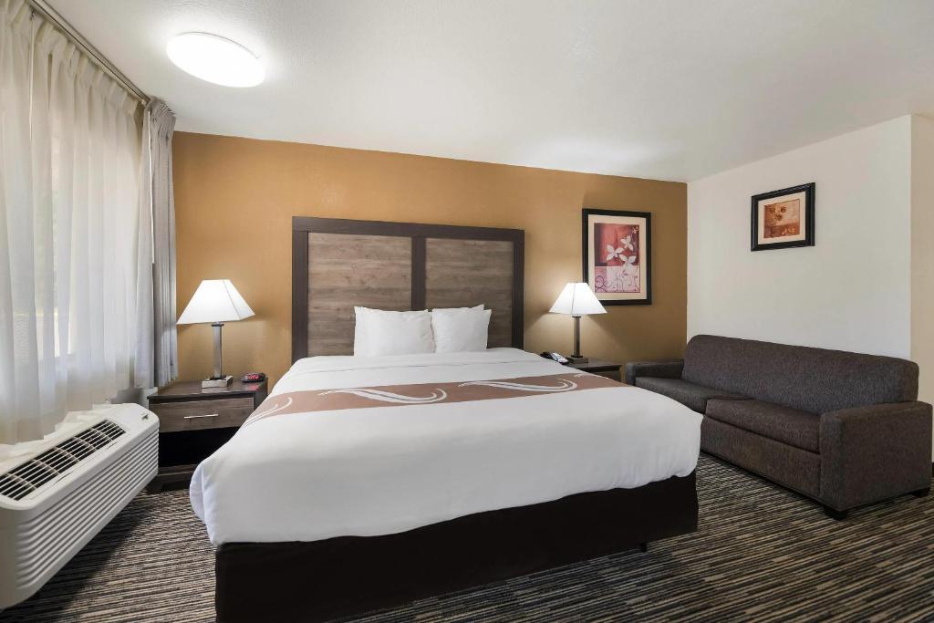 a hotel room with a large bed and a couch at Quality Inn & Suites Lufkin in Lufkin