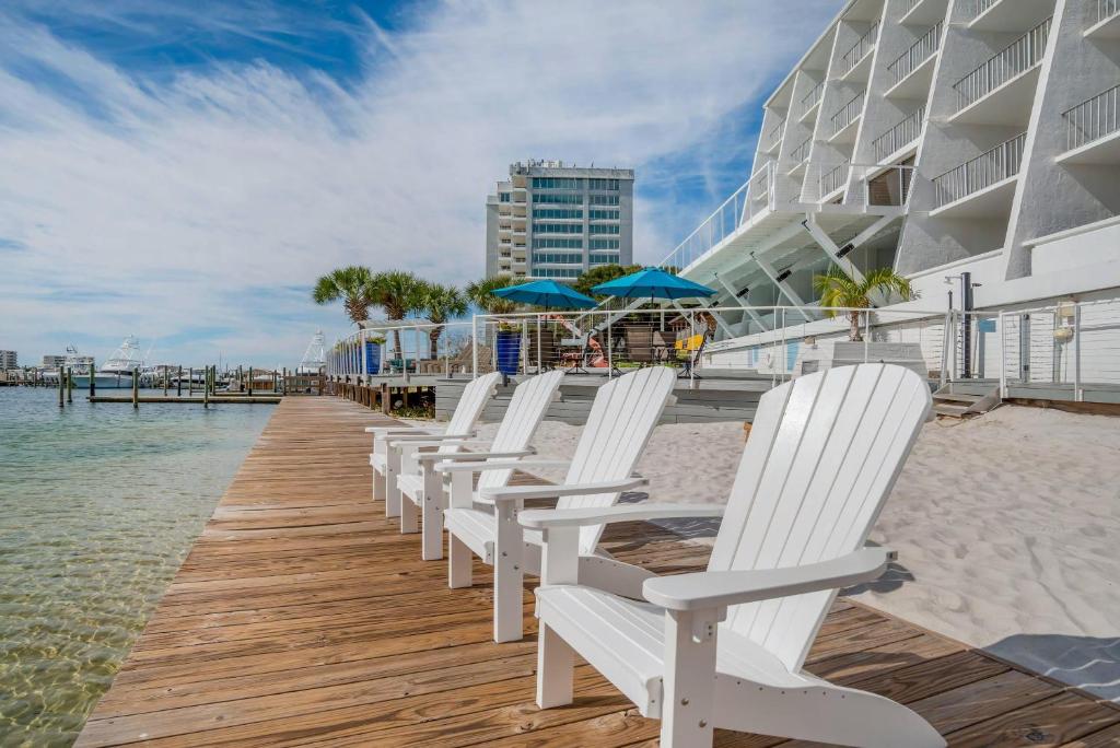 a row of white chairs sitting on a wooden dock at Inn on Destin Harbor, an Ascend Collection Hotel in Destin