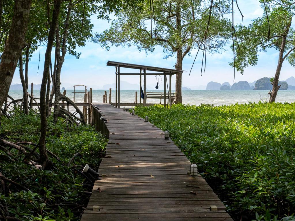 a wooden pathway leading to the beach at Bananas Resort & Restaurant in Tha Lane Bay