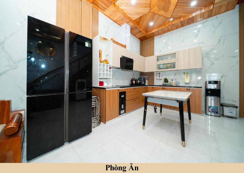 a kitchen with a black refrigerator and a table at Green Homestay in Danang