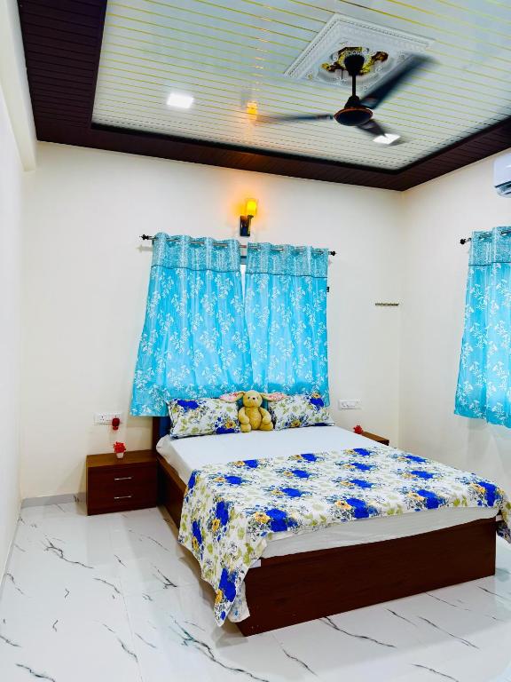 a bedroom with a bed with blue curtains at Kohinoor villa in Lonavala