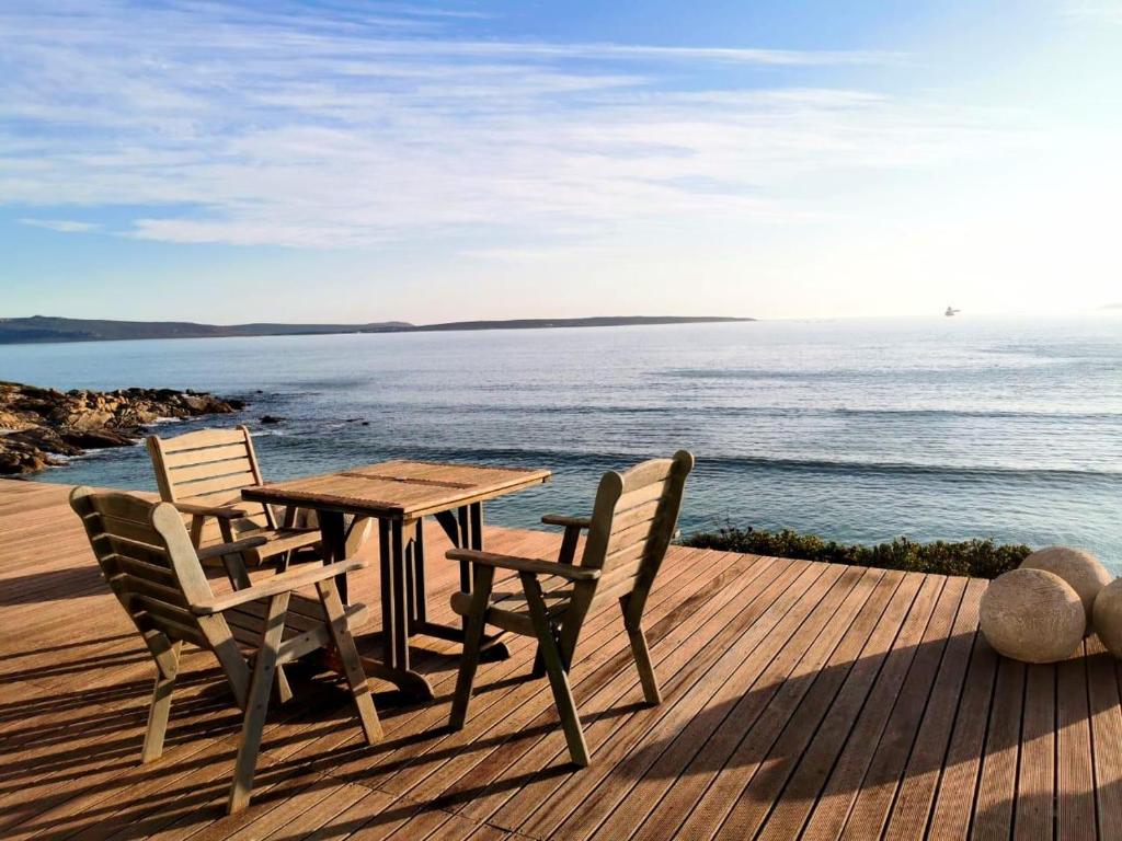 a table and chairs sitting on a deck overlooking the water at Langebaan Beach Towers in Langebaan