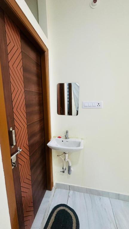 a bathroom with a sink and a wooden door at Vishwa Adithya Service Apts in Venkatāpur
