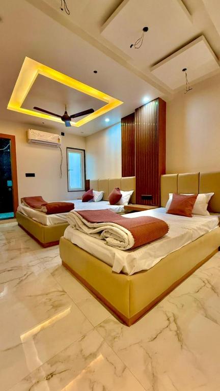 two large beds in a large room with at HOTEL RR Grand in Varanasi