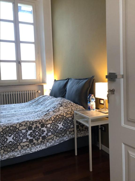 a bedroom with a bed with a desk and a window at Camera Albergo - Suites Mansion in Rozzano