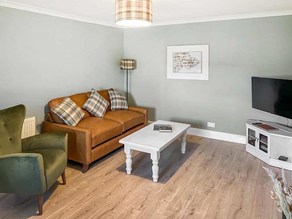 a living room with a couch and a coffee table at Rose Cottage in Freuchie