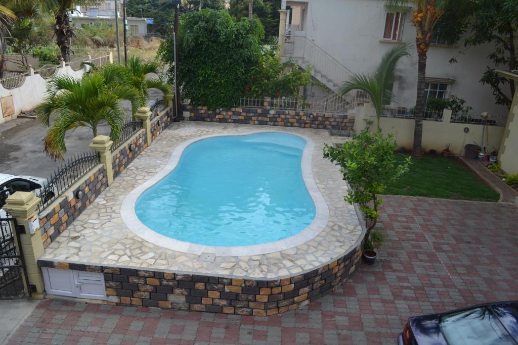 a large swimming pool in a yard with a house at RS VILLA private apartment with pool and free wifi in Flic-en-Flac