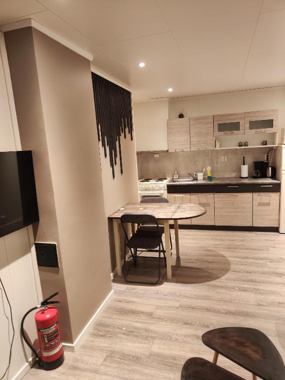 a kitchen with a table and chairs in a room at apartament by the sea in Havøysund