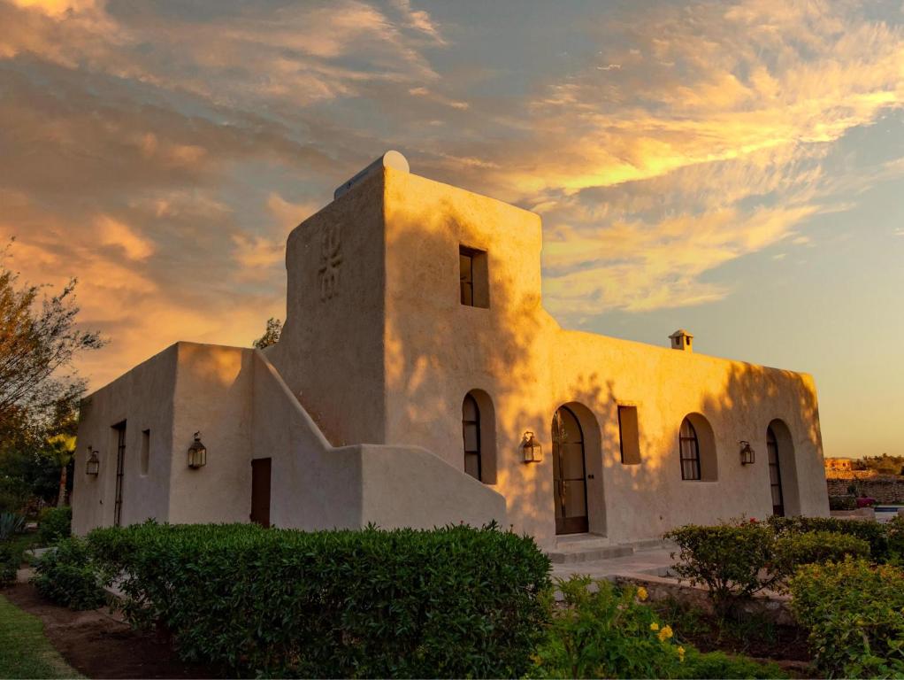 a white building with a sunset in the background at Villa BERBERINE in Essaouira