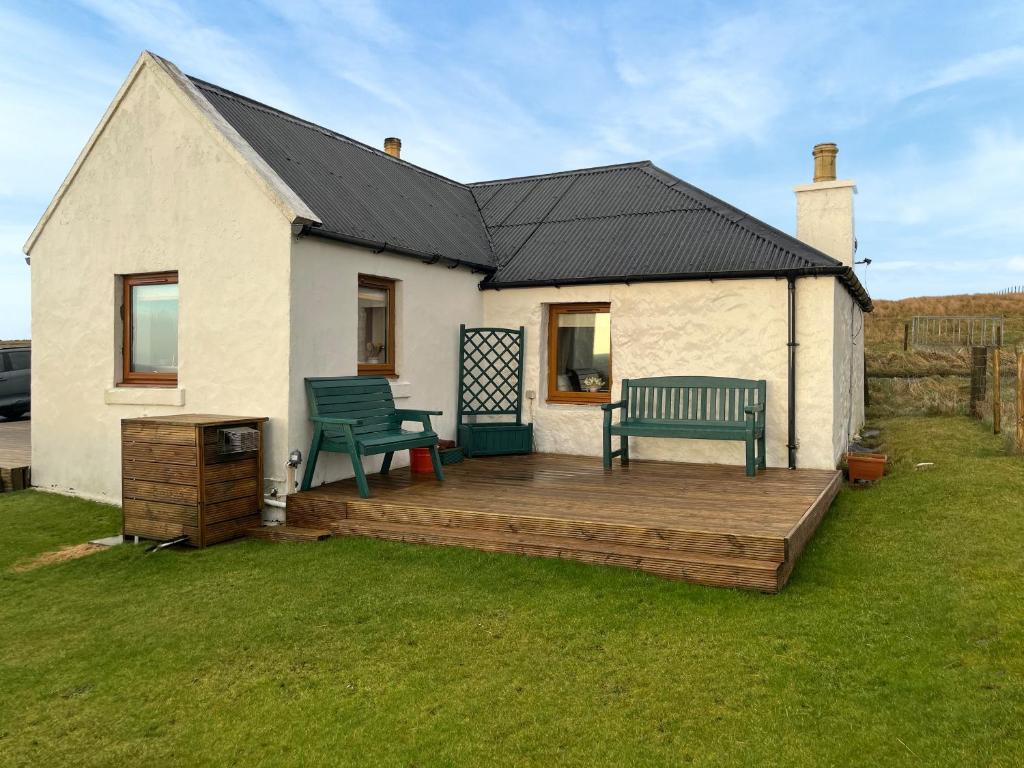 a house with a deck with two benches on it at Bothan Aonghais in Portree