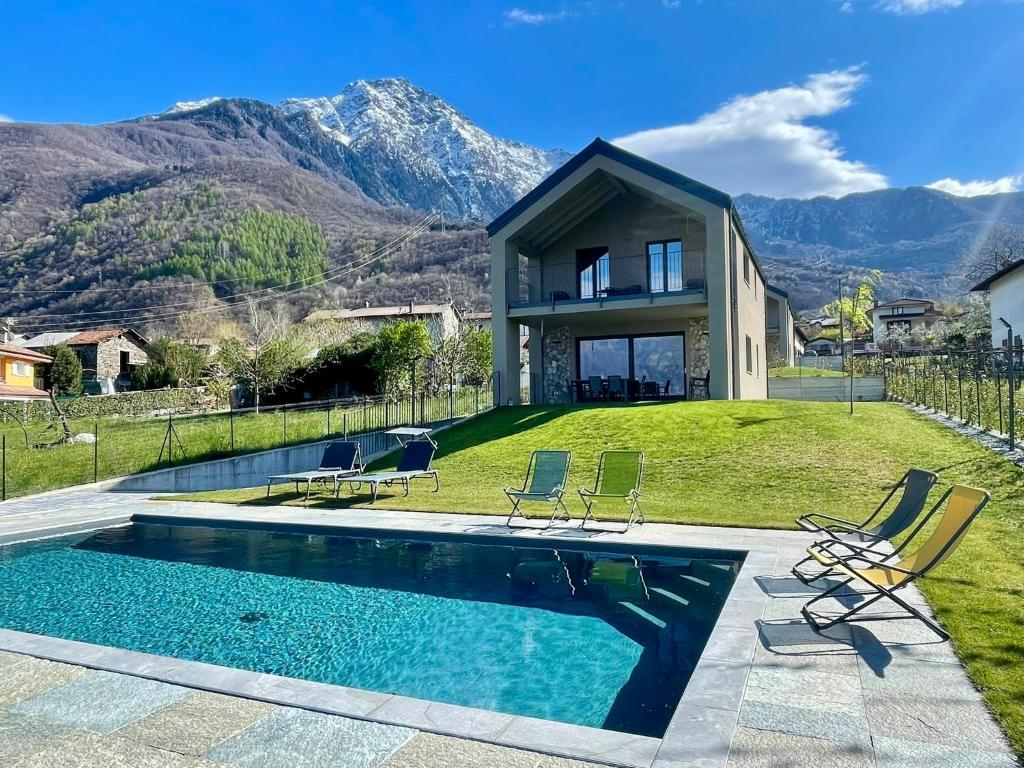 a house with a swimming pool with mountains in the background at Villa Tarca - Colico, Lake Como in Colico