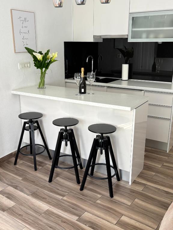 a kitchen with a white counter and two stools at Studio Apartman Fictilis in Split