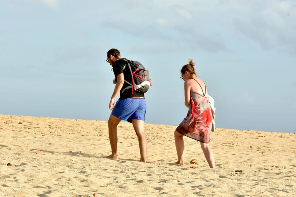 a man and a woman walking on the beach at Abey Villa Madiha Beach Surf Stay in Matara