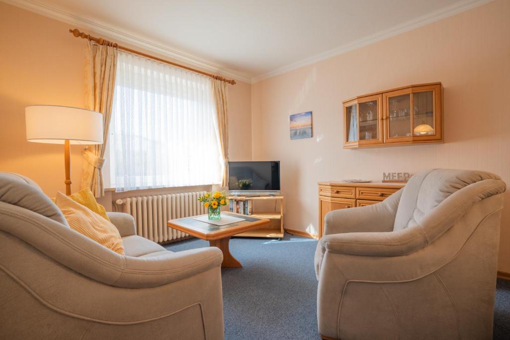 a living room with two chairs and a television at Kim im Haus Wega in Westerland