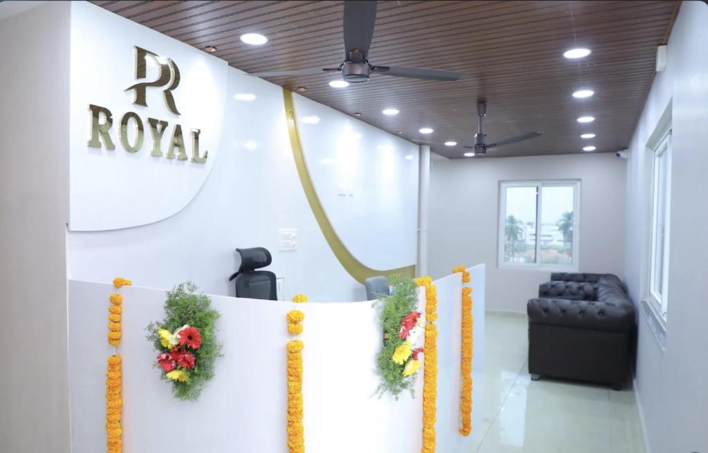 a corporate hall with a r royale sign and flowers at Hotel PR Royal in Bhīmavaram