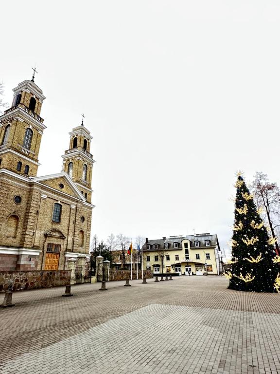 a christmas tree in front of a building with a church at Vievis Hotel Vievija in Vievis