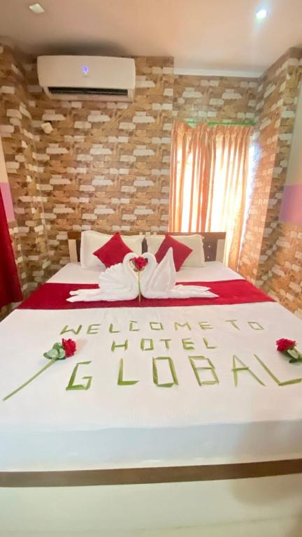 a bedroom with a large white bed with flowers on it at Global hotel in Pānigata