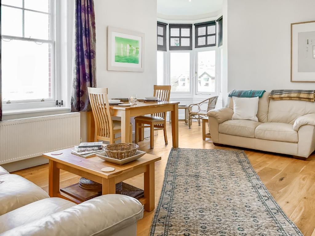 a living room with a table and a couch at Flat 4 Sea Court in Swanage