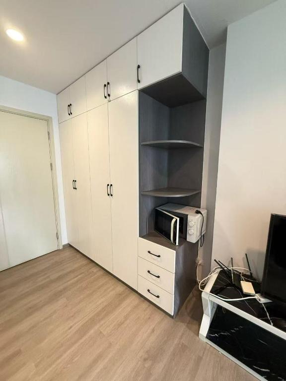 a room with white cabinets and a printer and a television at Regenthome 28A in Bang Su