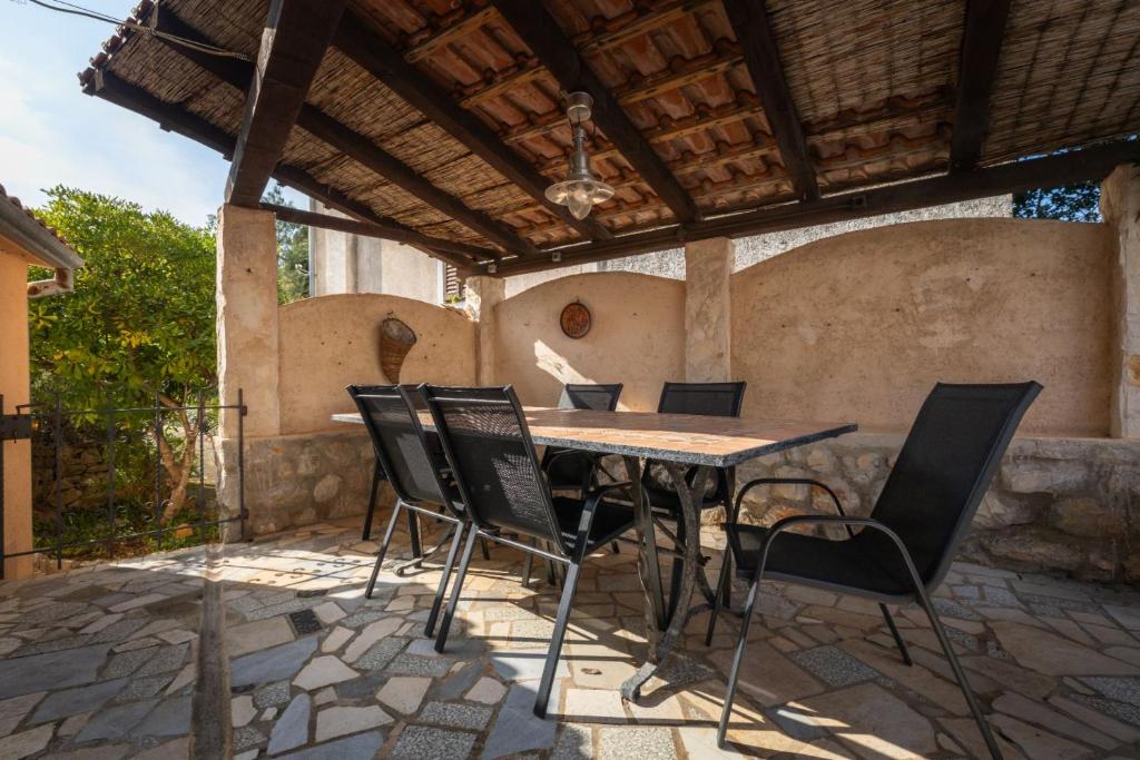 a table and chairs on an outdoor patio at House Nešpula in Veli Lošinj