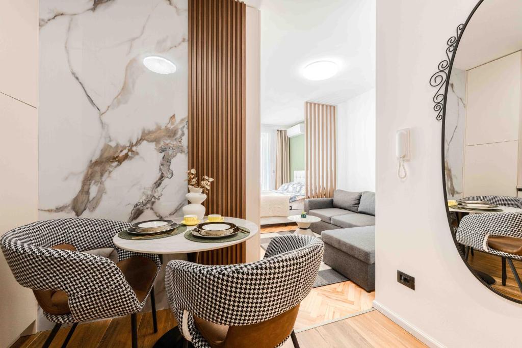 a living room with a table and chairs and a mirror at Stella Andrea Luxury Apartment in Bar