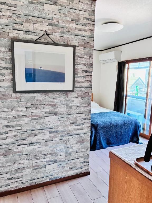 a room with a stone wall with a tv on it at 蓮子川Room in Hamamatsu